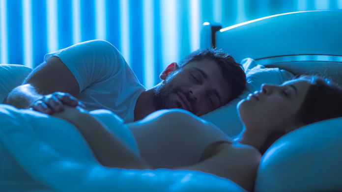 Pareja dormida en una cama