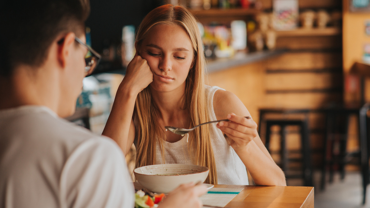 Mujer rubia cansada comiendo