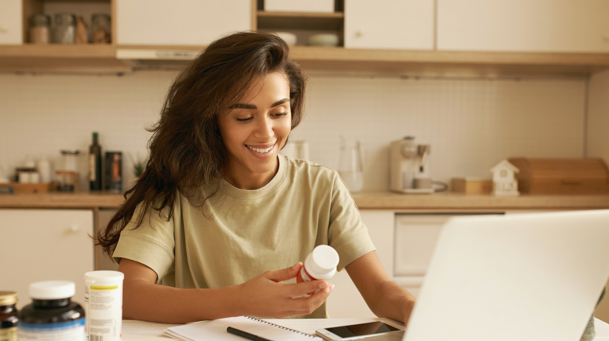 Jeune femme qui choisit son complément multivitaminé