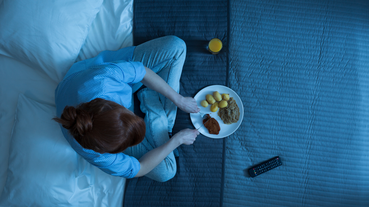 La mujer que come por la noche en su cama